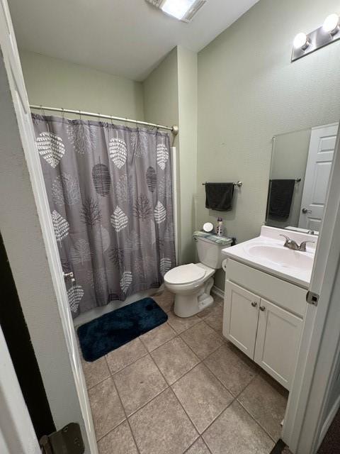 bathroom featuring walk in shower, tile patterned floors, toilet, and vanity