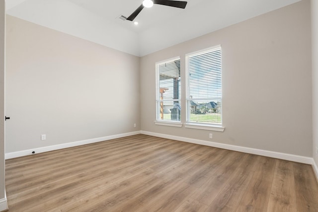 spare room featuring vaulted ceiling, ceiling fan, and light wood-type flooring