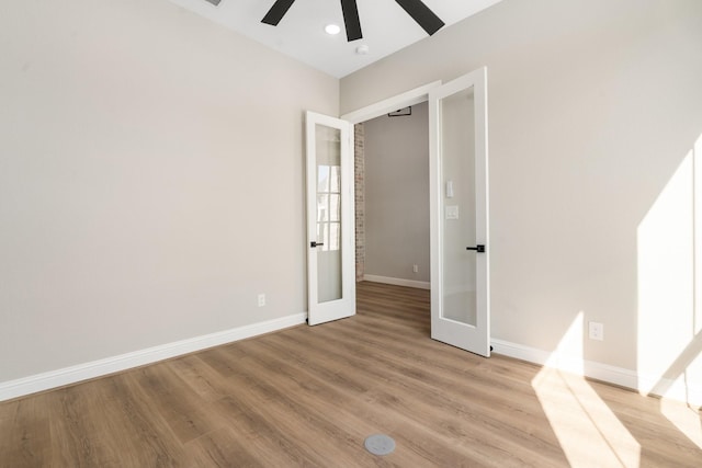 unfurnished bedroom featuring french doors, ceiling fan, and light hardwood / wood-style flooring