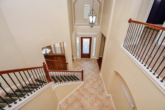 tiled entrance foyer featuring a chandelier and a high ceiling