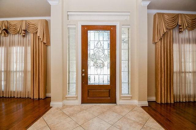 tiled entryway featuring ornamental molding