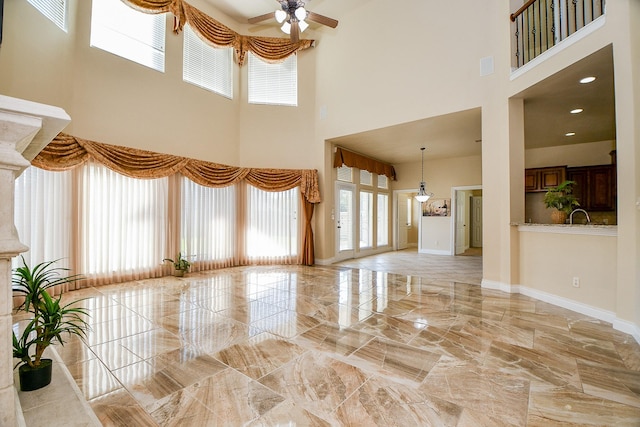 unfurnished living room with ceiling fan and sink