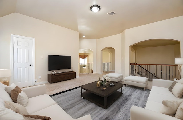 carpeted living room with lofted ceiling