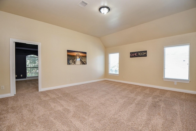 spare room featuring lofted ceiling and carpet