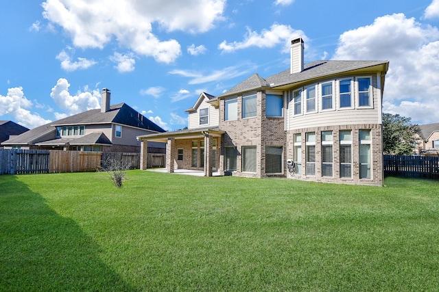 rear view of property with a lawn and a patio area