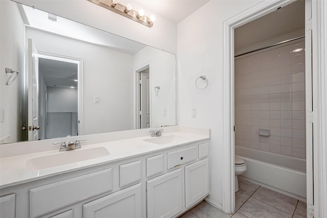 full bathroom with vanity, tiled shower / bath, tile patterned floors, and toilet