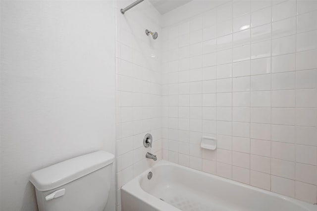 bathroom featuring tiled shower / bath and toilet