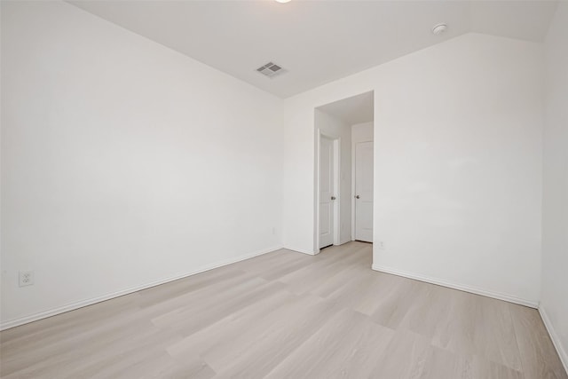 unfurnished room with lofted ceiling and light hardwood / wood-style floors