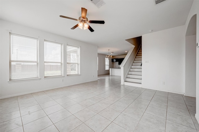 unfurnished living room with light tile patterned flooring and ceiling fan with notable chandelier