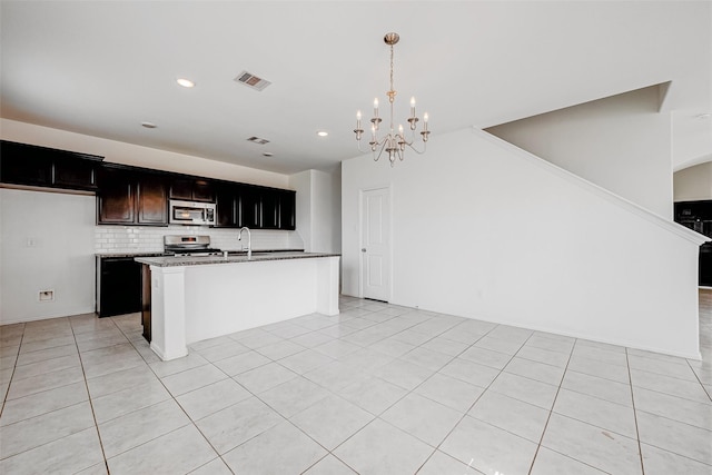 kitchen with sink, tasteful backsplash, decorative light fixtures, a center island with sink, and appliances with stainless steel finishes