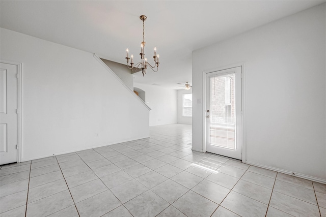 tiled empty room with ceiling fan with notable chandelier