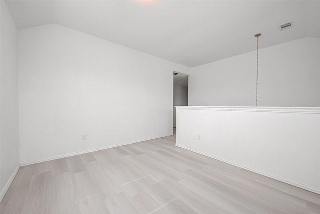 unfurnished room featuring vaulted ceiling and light wood-type flooring