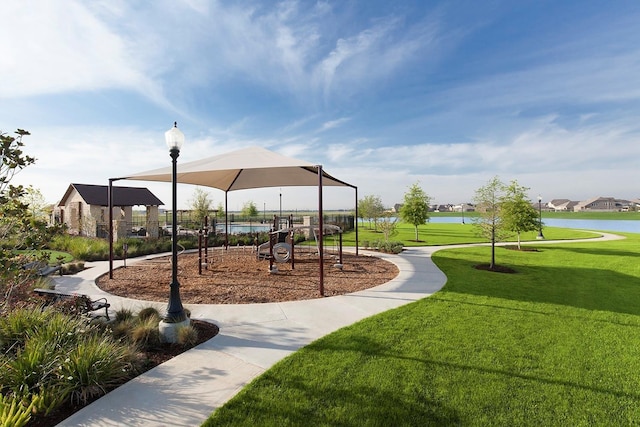 view of property's community with a water view, a playground, and a lawn