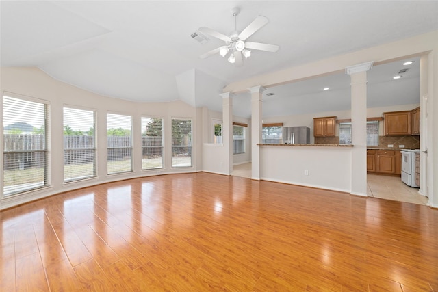 unfurnished living room with ornate columns, ceiling fan, and light wood-type flooring