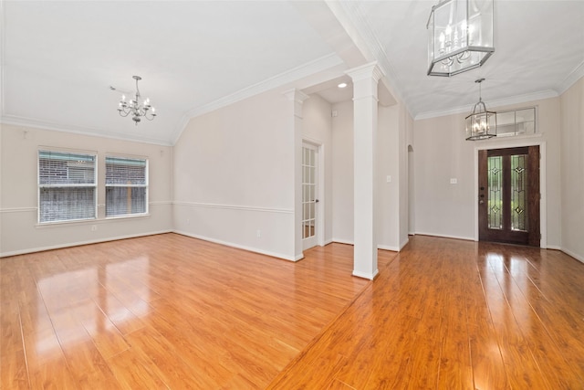 entrance foyer with an inviting chandelier, wood-type flooring, and ornate columns