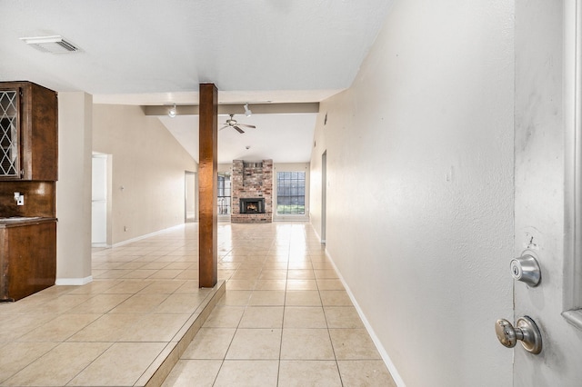 hall with lofted ceiling and light tile patterned floors