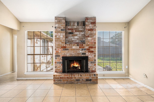 unfurnished living room featuring a fireplace and light tile patterned flooring