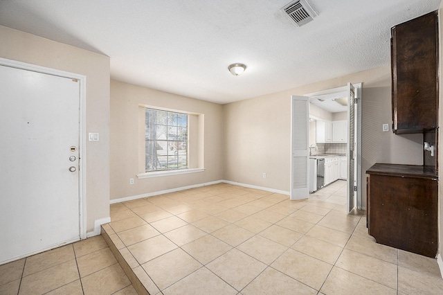 unfurnished dining area featuring light tile patterned flooring and sink