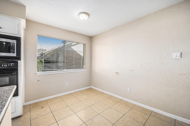 unfurnished dining area featuring light tile patterned flooring