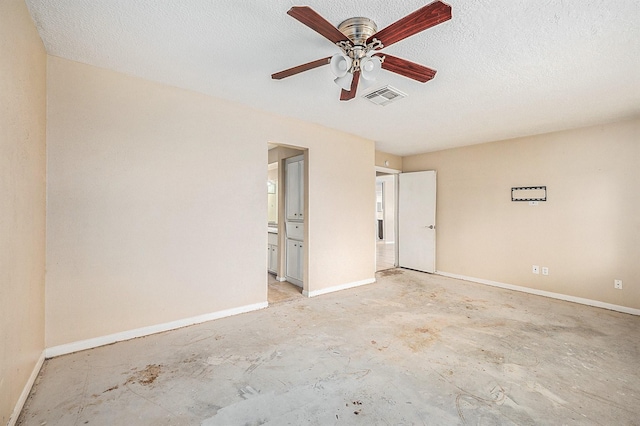 empty room with ceiling fan and a textured ceiling