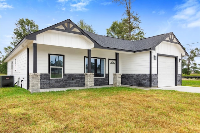 modern farmhouse style home featuring a garage, a front lawn, central air condition unit, and covered porch