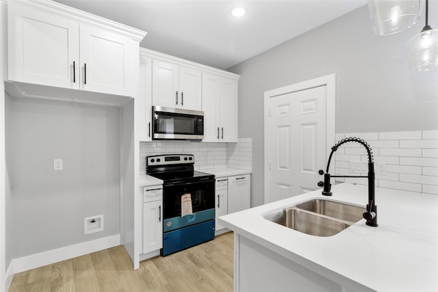 kitchen with decorative light fixtures, sink, white cabinets, electric range, and light hardwood / wood-style flooring