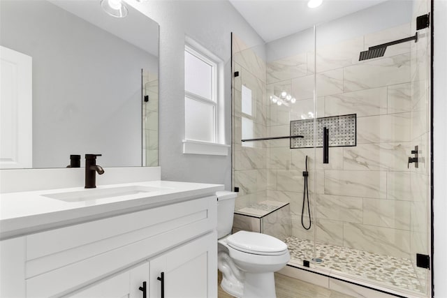 bathroom with an enclosed shower, vanity, and toilet