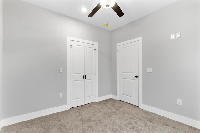 unfurnished bedroom featuring light colored carpet, a closet, and ceiling fan