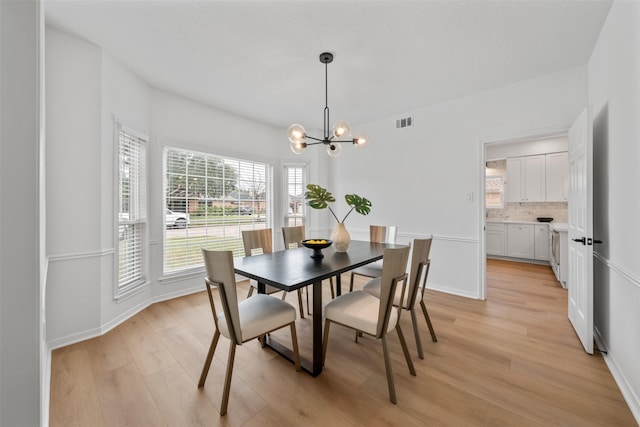 dining area with a chandelier and light hardwood / wood-style floors