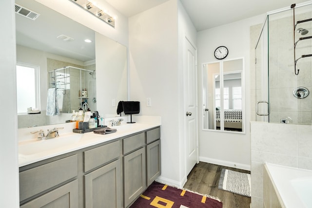 bathroom with hardwood / wood-style flooring, vanity, and separate shower and tub