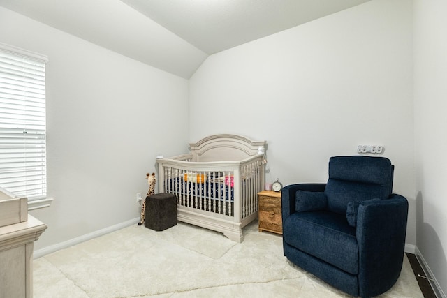 carpeted bedroom featuring lofted ceiling, a crib, and multiple windows