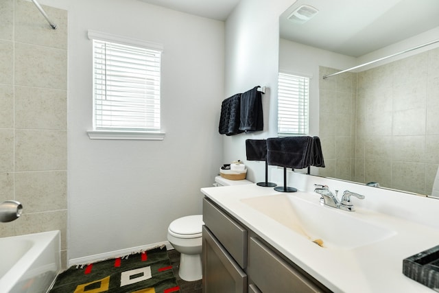 full bathroom featuring tiled shower / bath combo, vanity, and toilet