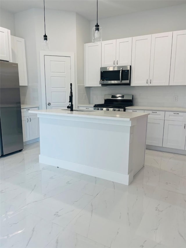 kitchen featuring stainless steel appliances, pendant lighting, and white cabinets