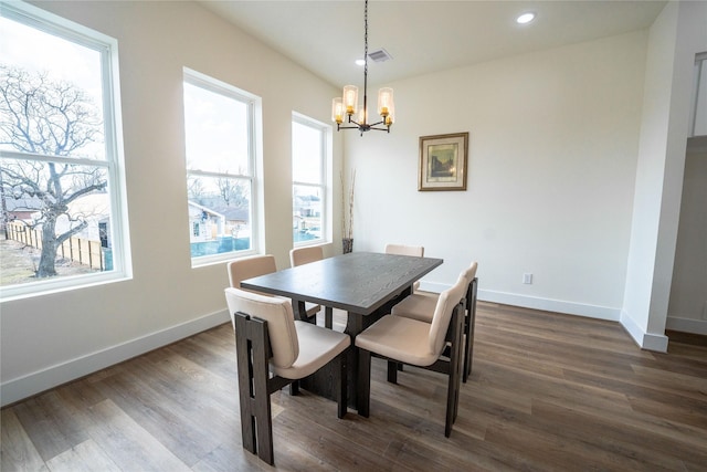 dining room with dark hardwood / wood-style flooring and a chandelier