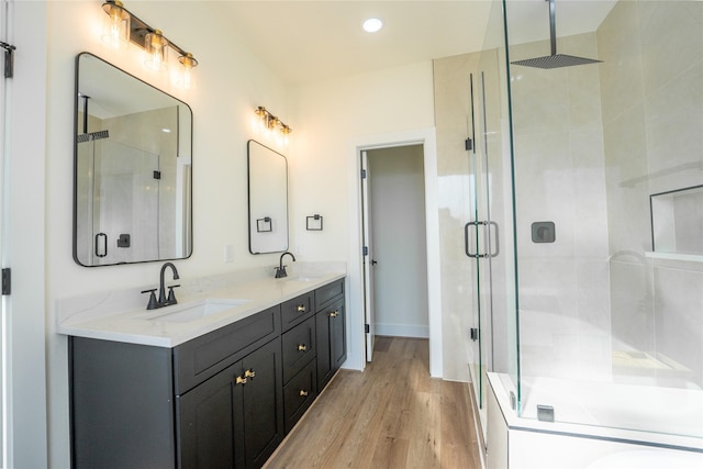 bathroom featuring hardwood / wood-style flooring, vanity, and walk in shower