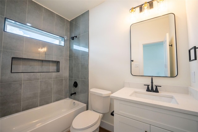 full bathroom featuring vanity, tiled shower / bath combo, and toilet