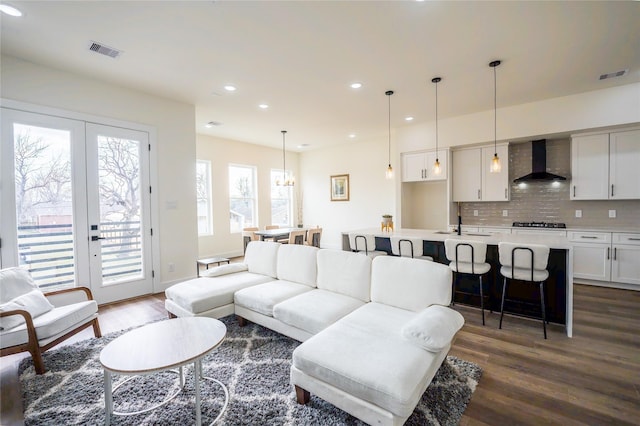 living room with dark wood-type flooring, sink, and french doors