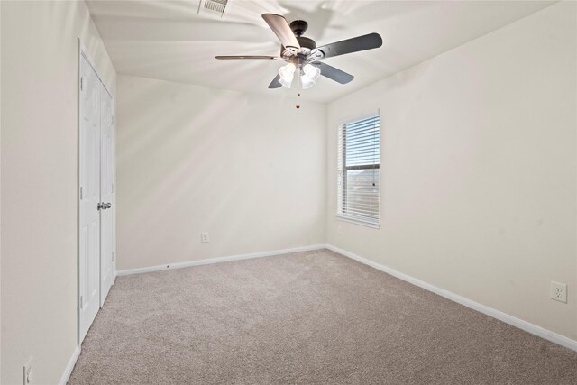 spare room featuring light colored carpet and ceiling fan