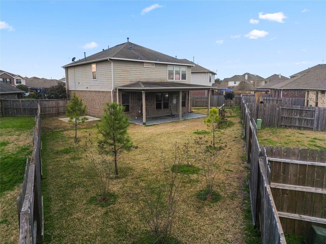 back of house with a patio area and a lawn