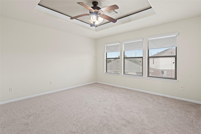 unfurnished room with ceiling fan, carpet flooring, and a raised ceiling