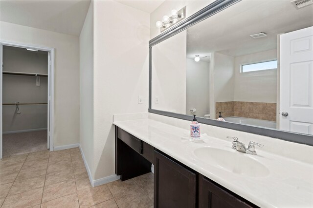 bathroom featuring vanity, tile patterned floors, and a tub