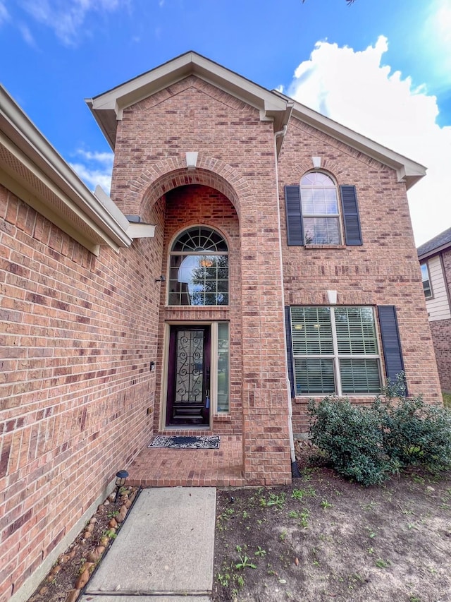 doorway to property featuring brick siding