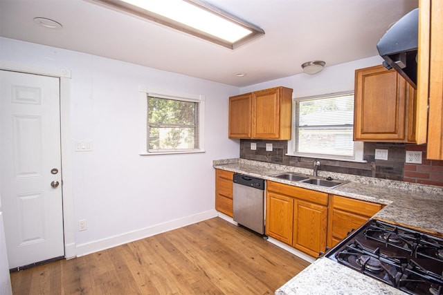 kitchen with decorative backsplash, brown cabinets, light wood-type flooring, stainless steel dishwasher, and a sink