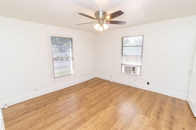 empty room featuring a healthy amount of sunlight, light wood-style floors, and baseboards