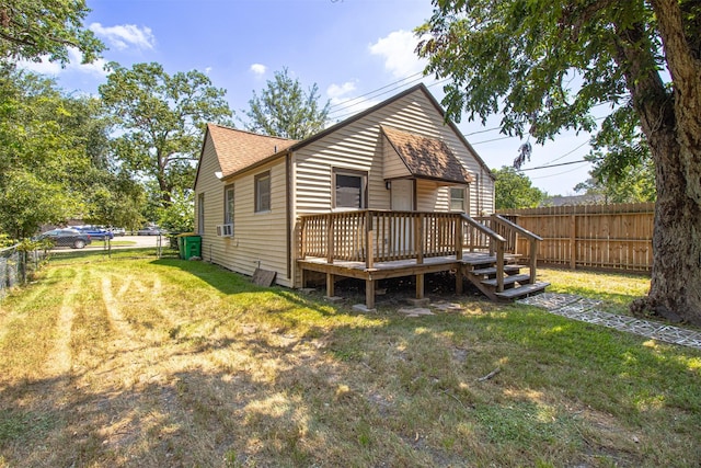 rear view of house featuring a fenced backyard, a lawn, and a wooden deck