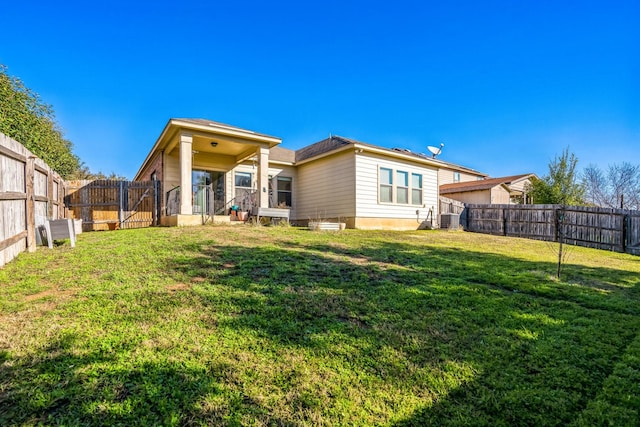 back of property with a yard and central AC