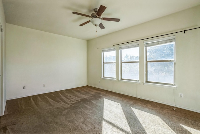 carpeted empty room with ceiling fan and plenty of natural light