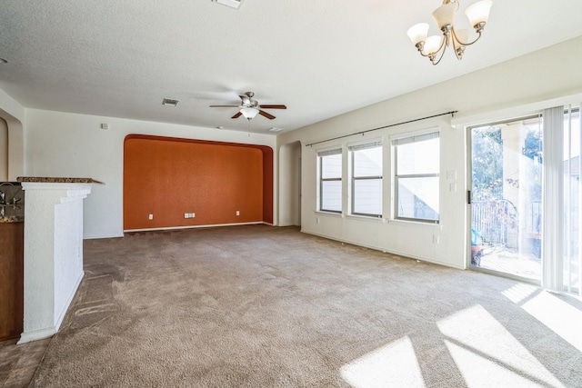 unfurnished living room with ceiling fan with notable chandelier, carpet floors, and a textured ceiling