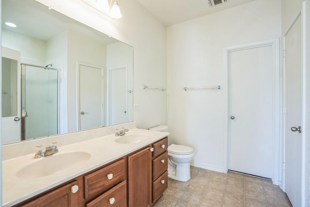 bathroom with vanity, a shower with shower door, and toilet