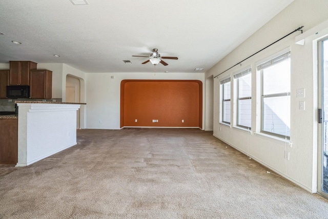 unfurnished living room with light carpet and ceiling fan